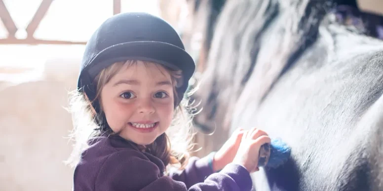 Little girl smiling with a horse