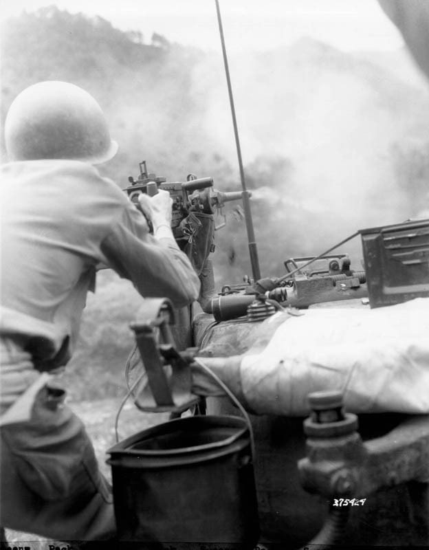 Soldier firing a machine gun on a hillside in Korea